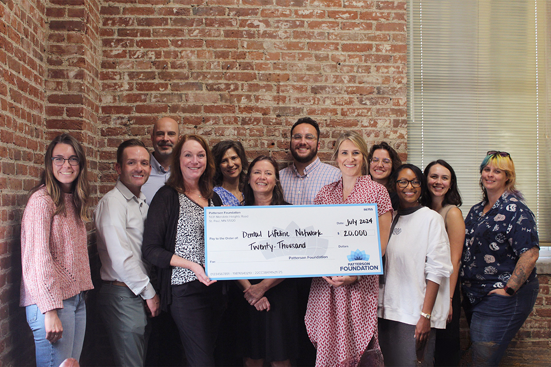 Patterson employees holding an oversized, promotional check