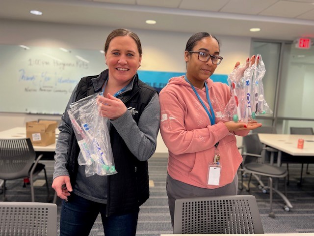 Two Patterson employees volunteering. They're assembling dental kits for nonprofits.