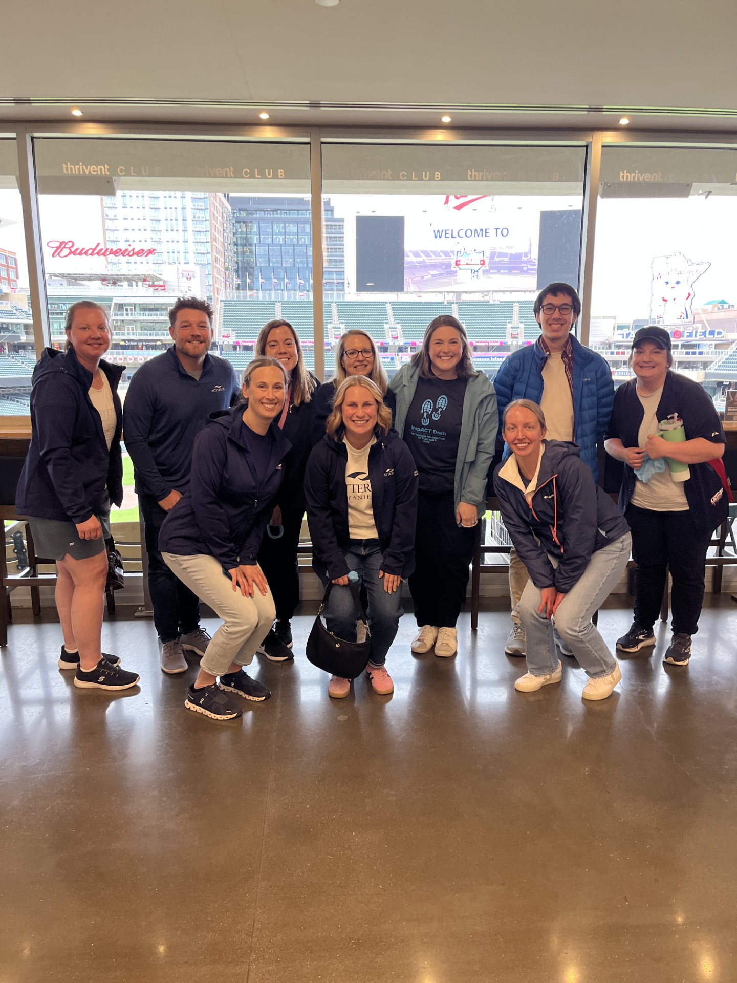 Smiling group of Patterson employees volunteering for Feed My Starving Children at the Minnesota Twins game.